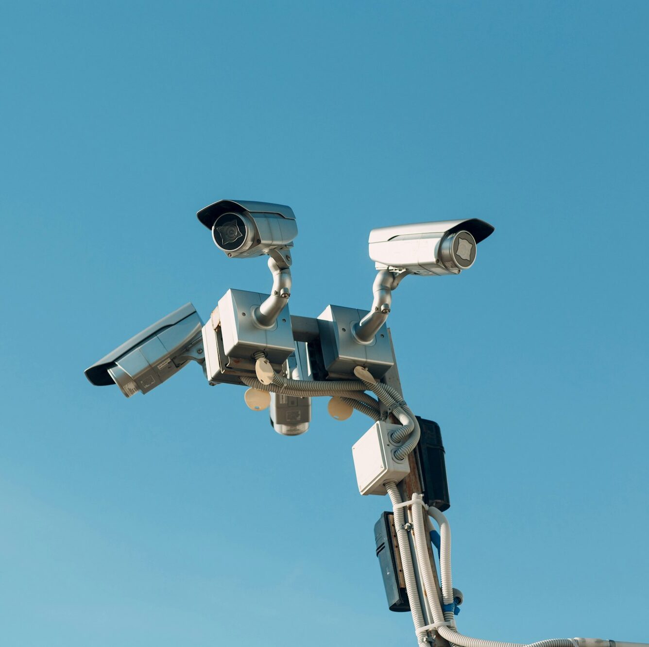 Surveillance camera on blue sky background